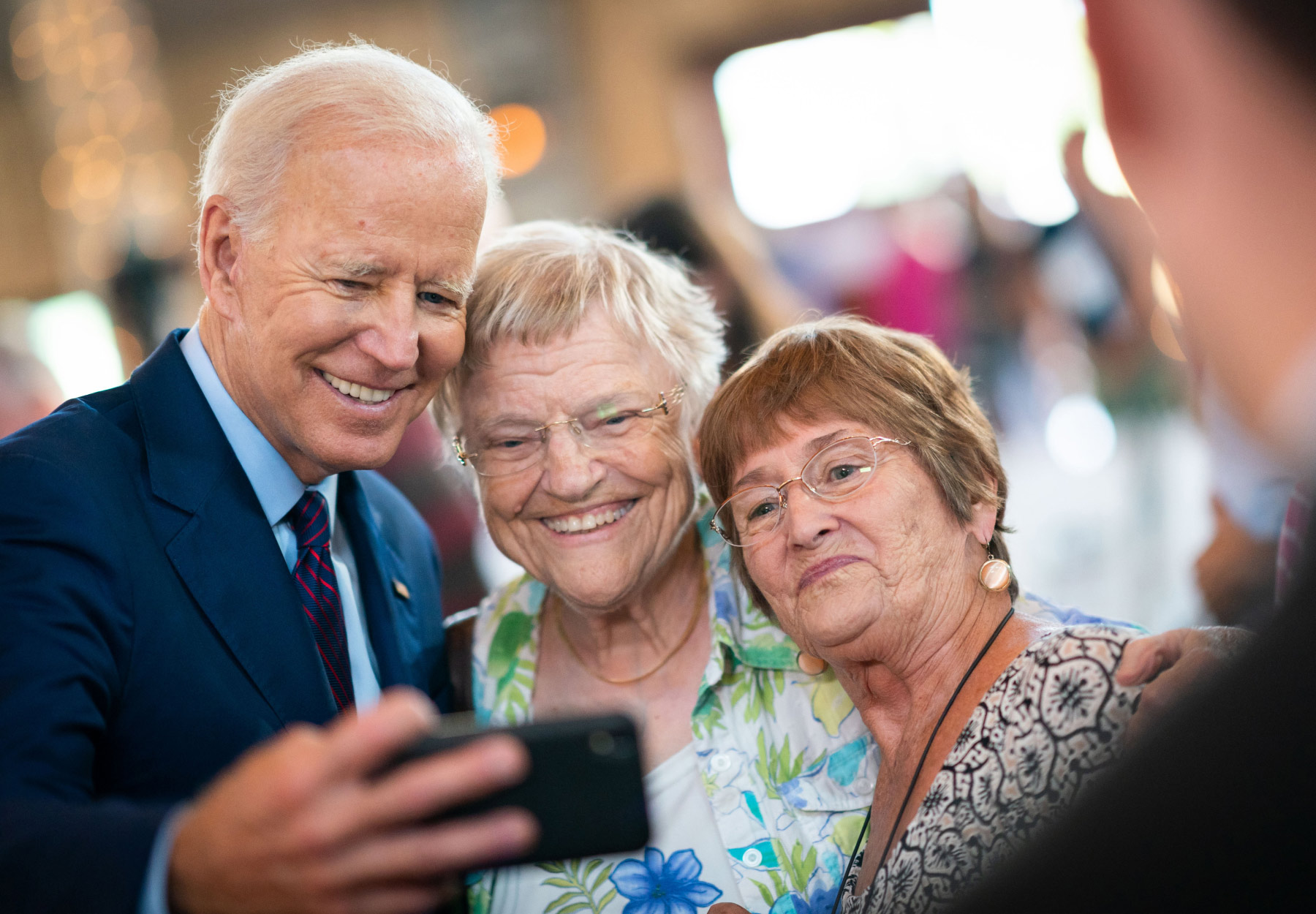 President Joe Biden takes a photo with attendees at an event in Burlington, IA